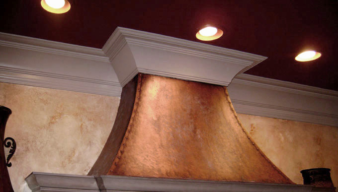 warm colored cabinet glazing with faux copper stove hood.
