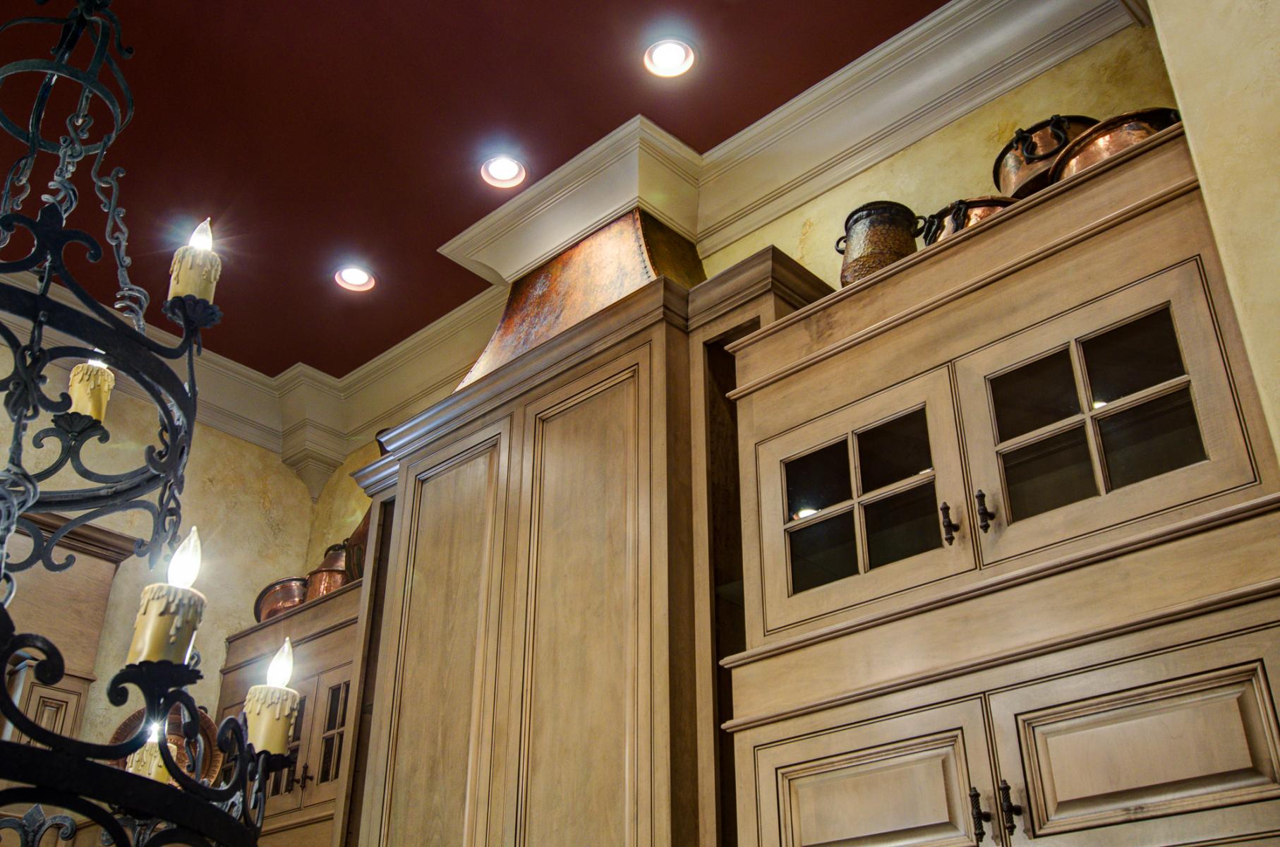 Tuscan colored plaster walls set against warm cabinet glazing and accented with a faux copper stove hood.