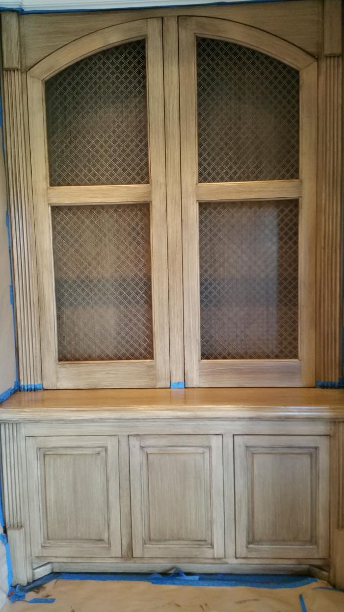 Wood grained built-in cabinets and painted feature wall and glazed hearth.