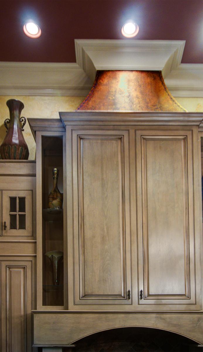 warm colored cabinet glazing with faux copper stove hood.