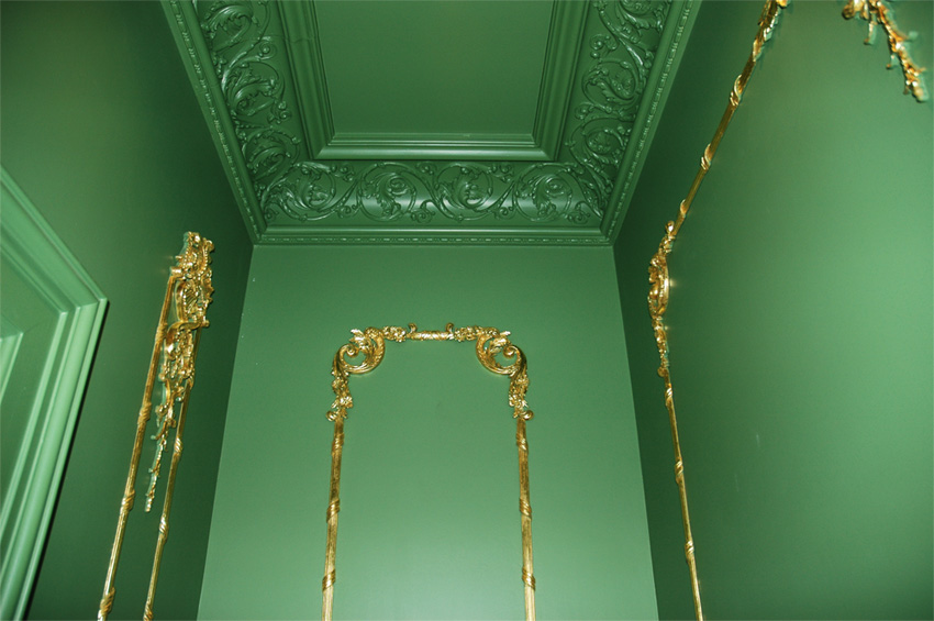 Gold leaf on millwork trim over Russian green colored panels.