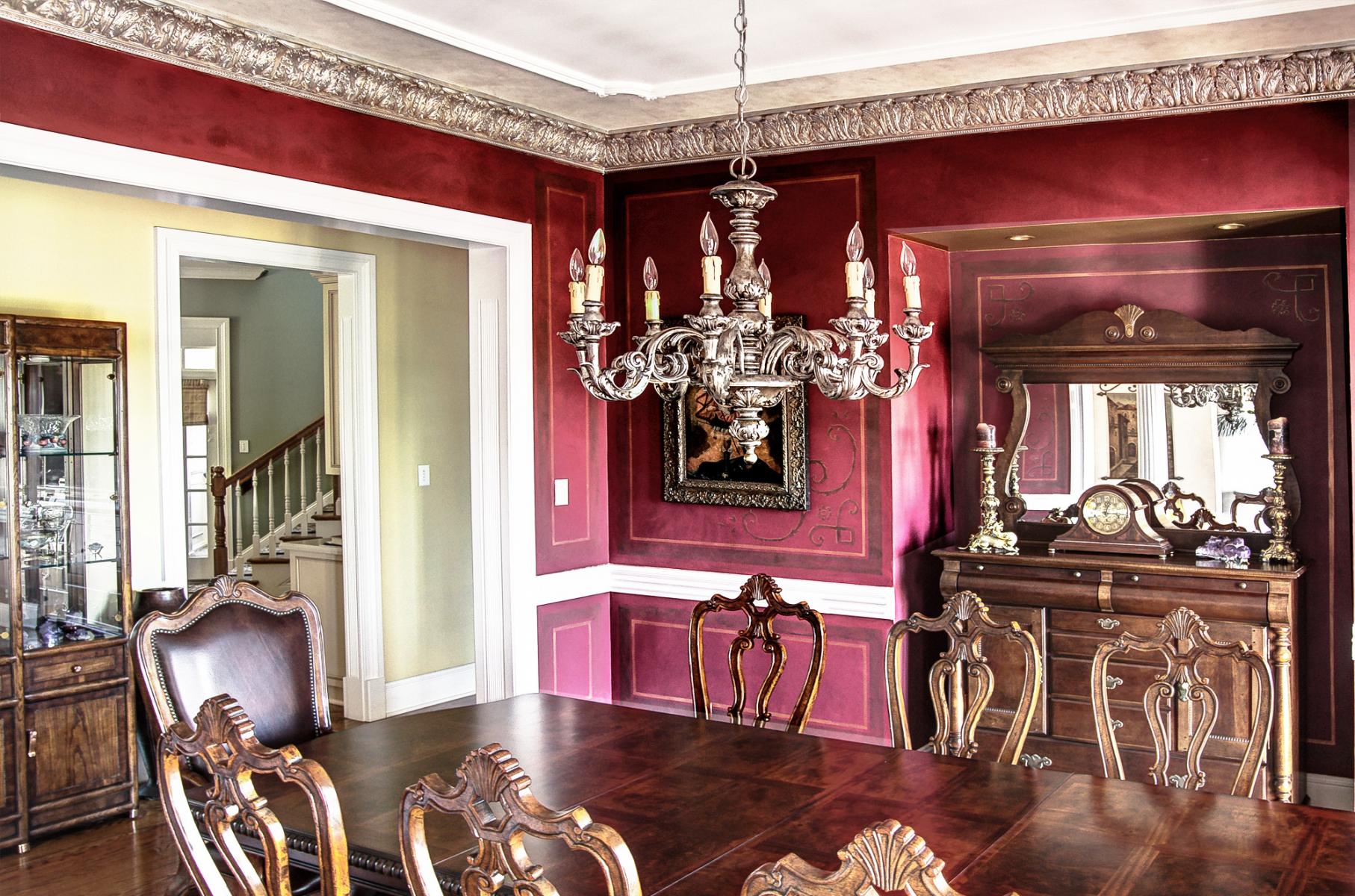 Stencil designs over wine colored walls with a faux metal plaster cornice and chandelier topped with an accented ceiling. Stunning!