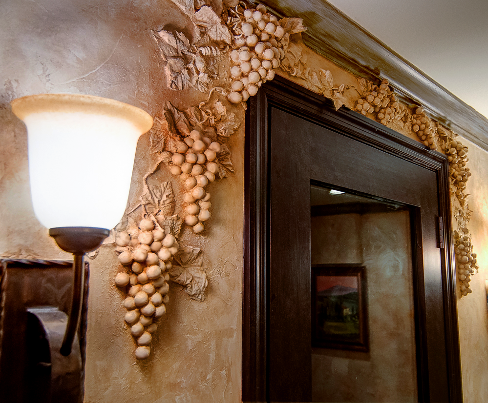 Faux Chiseled Grape Motif - embedded in the Tuscan plaster walls around wine cellar entry door.